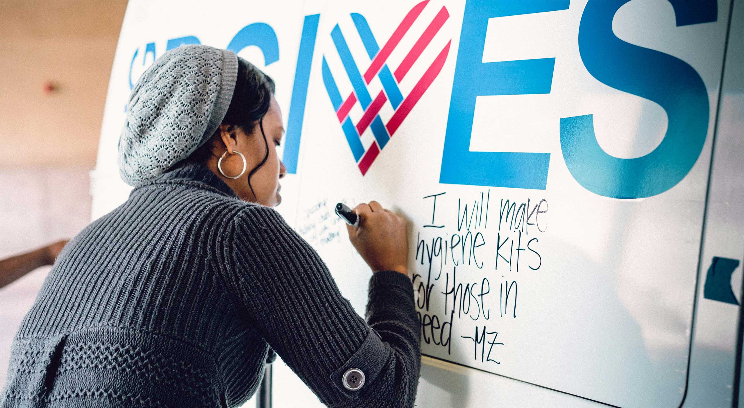 woman pledging to help on a Giving Tuesday poster