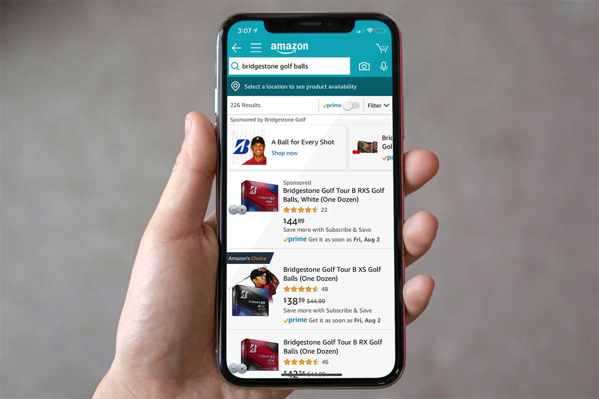 hand holding a cellphone with Bridgestone golf ball results from an Amazon search