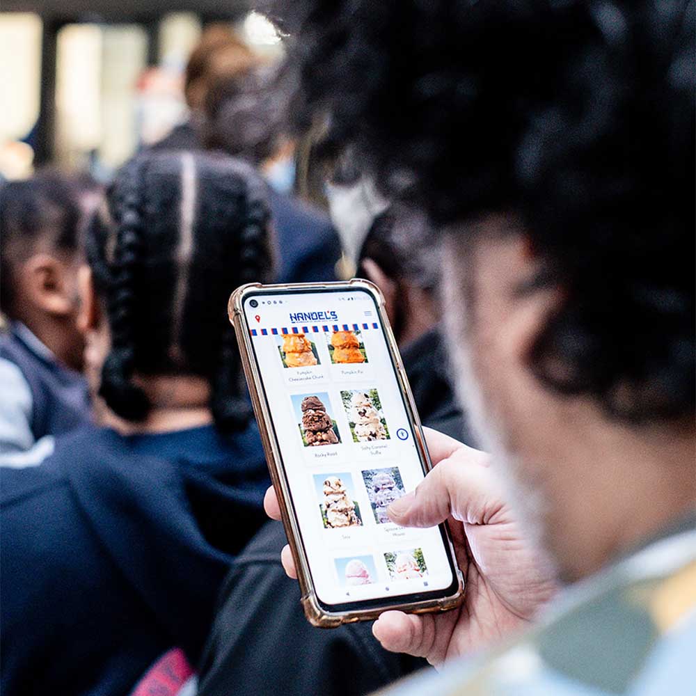 man scrolling the Handel's Ice Cream site on his mobile phone