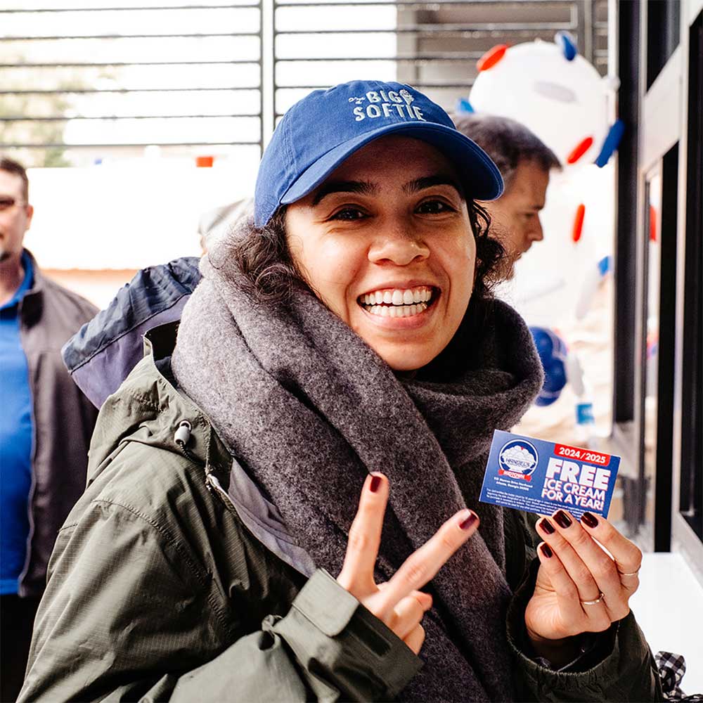 woman smiling and flashing a peace sign with Free Ice Cream For a Year entry card from Handel's Ice Cream