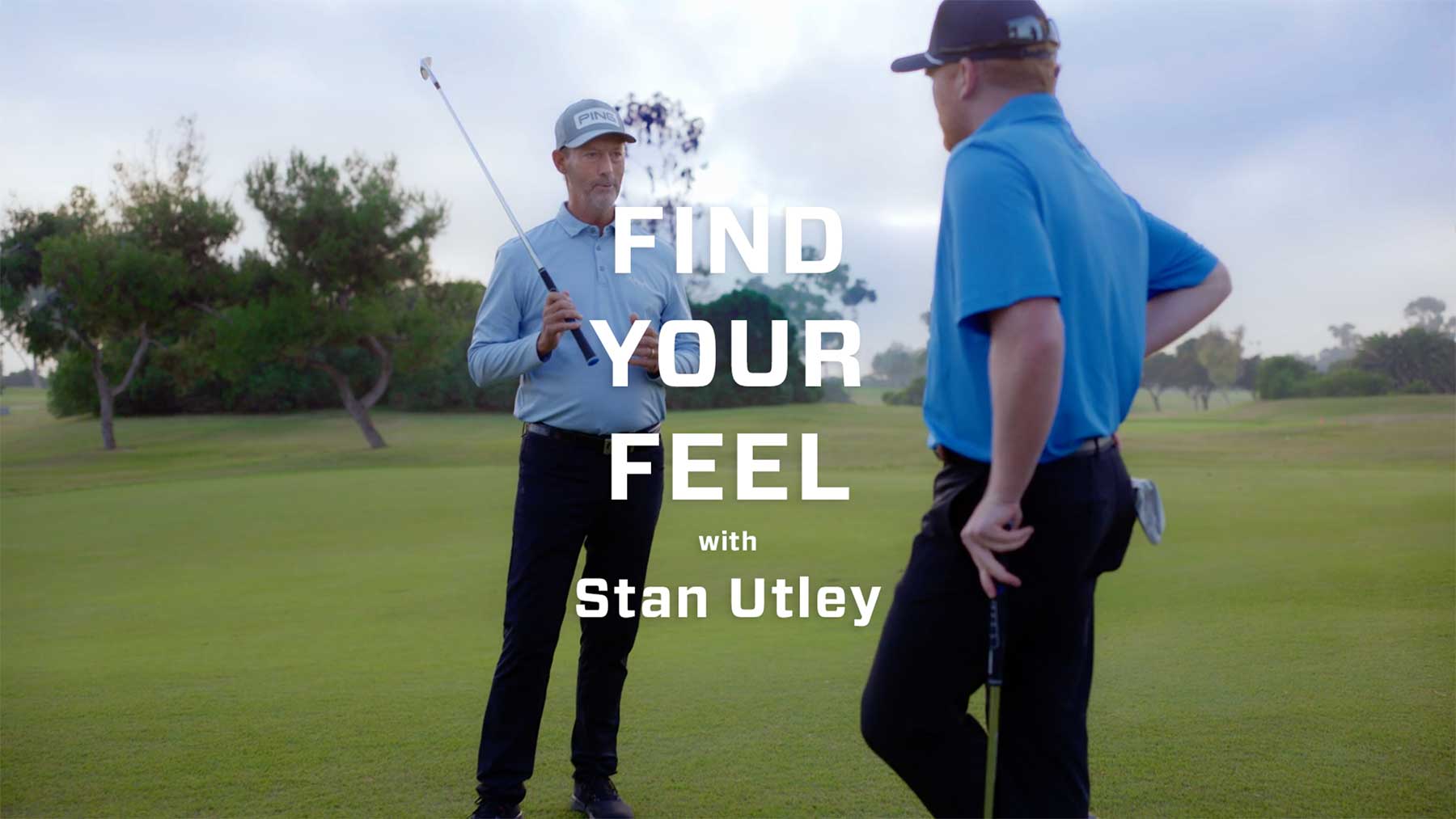 Stan Utley holding a putter and talking to another golfer