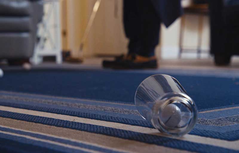 man putting into a glass in living room