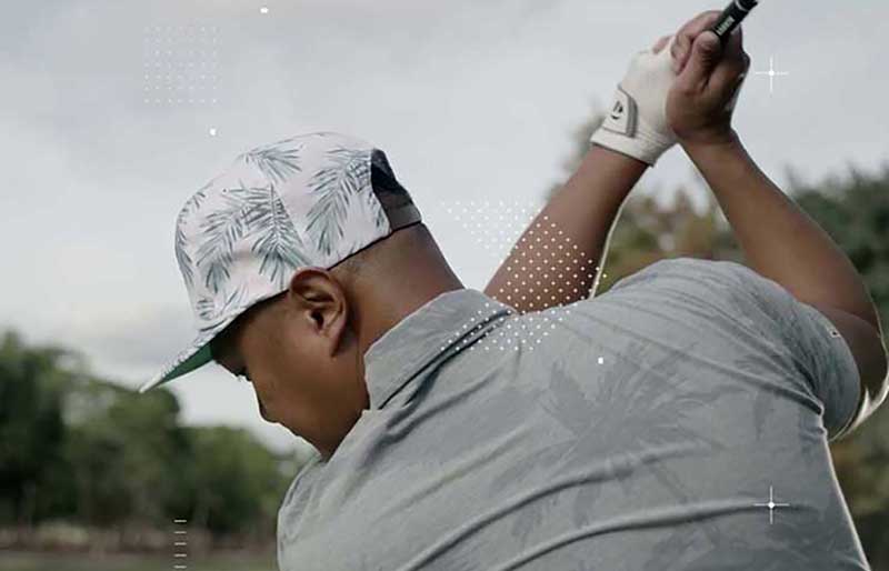 male golfer with head turned to drive the ball